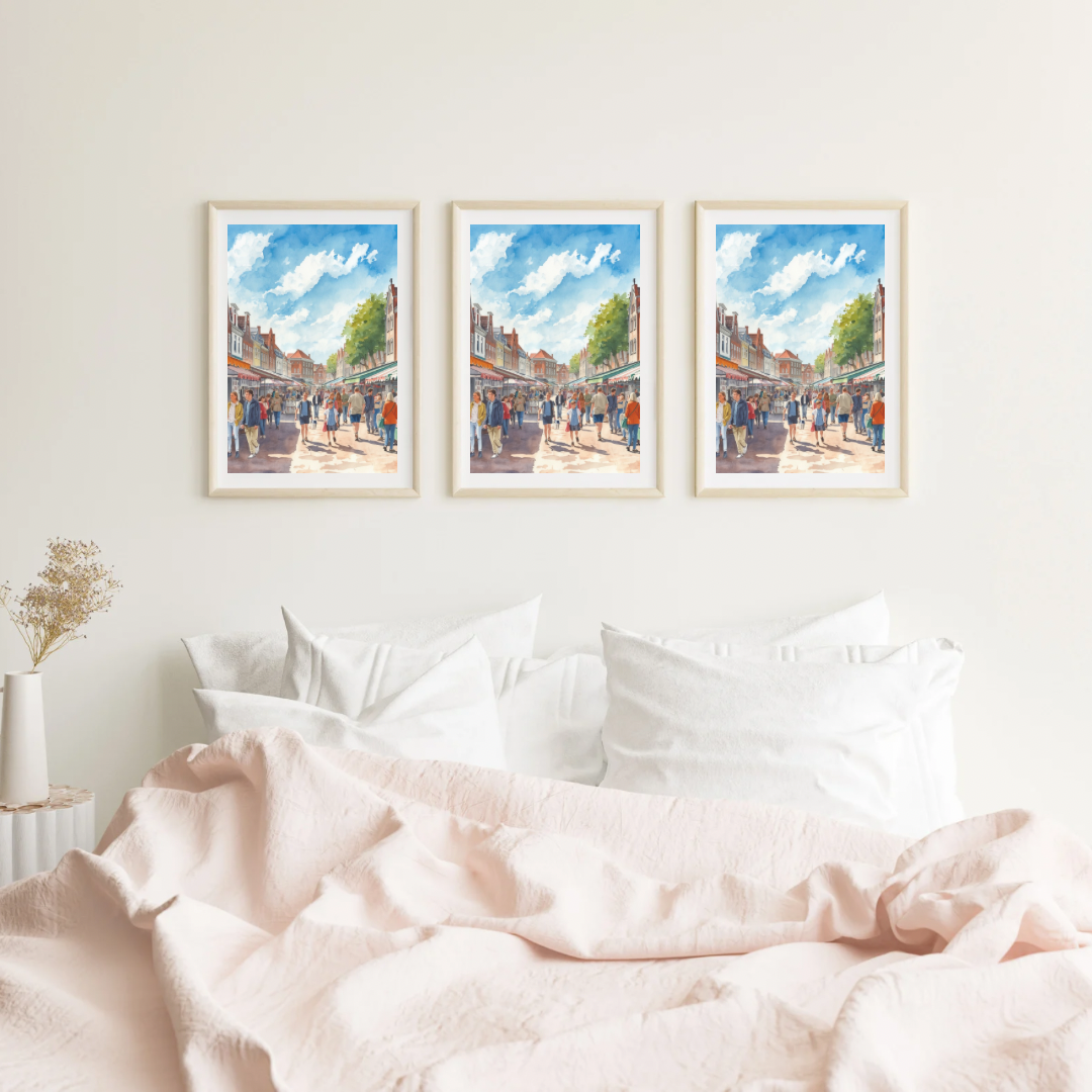 Deventer marktstraat schilderij als set van drie in witte lijst aan witte muur boven witte bank met zachte kussens – aquarel wall art woonkamer