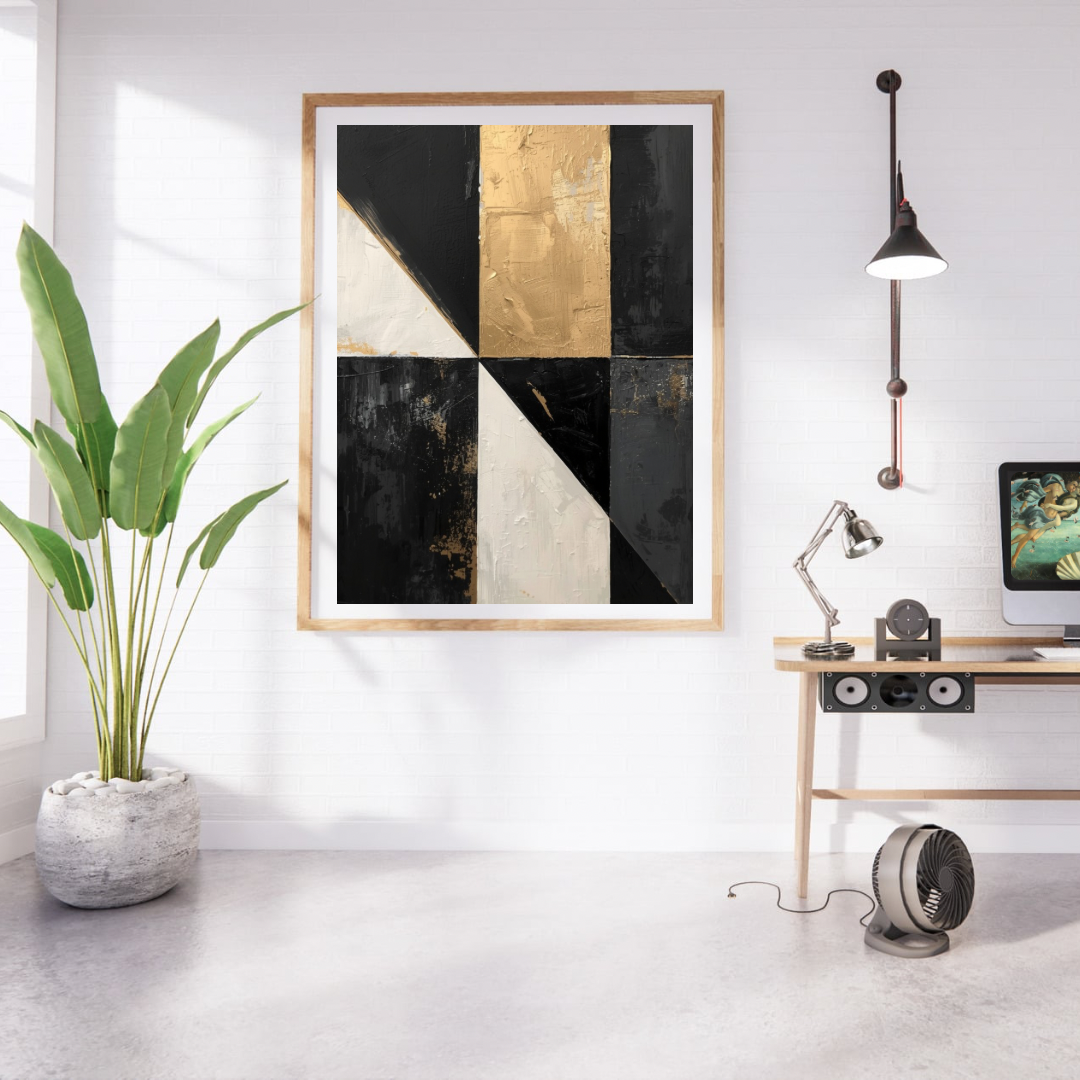 Abstract driehoeken zwart wit goud schilderij in naturel houten lijst aan witte muur naast grote groene plant en houten bureau met lamp – abstract olieverf wall art studeerkamer