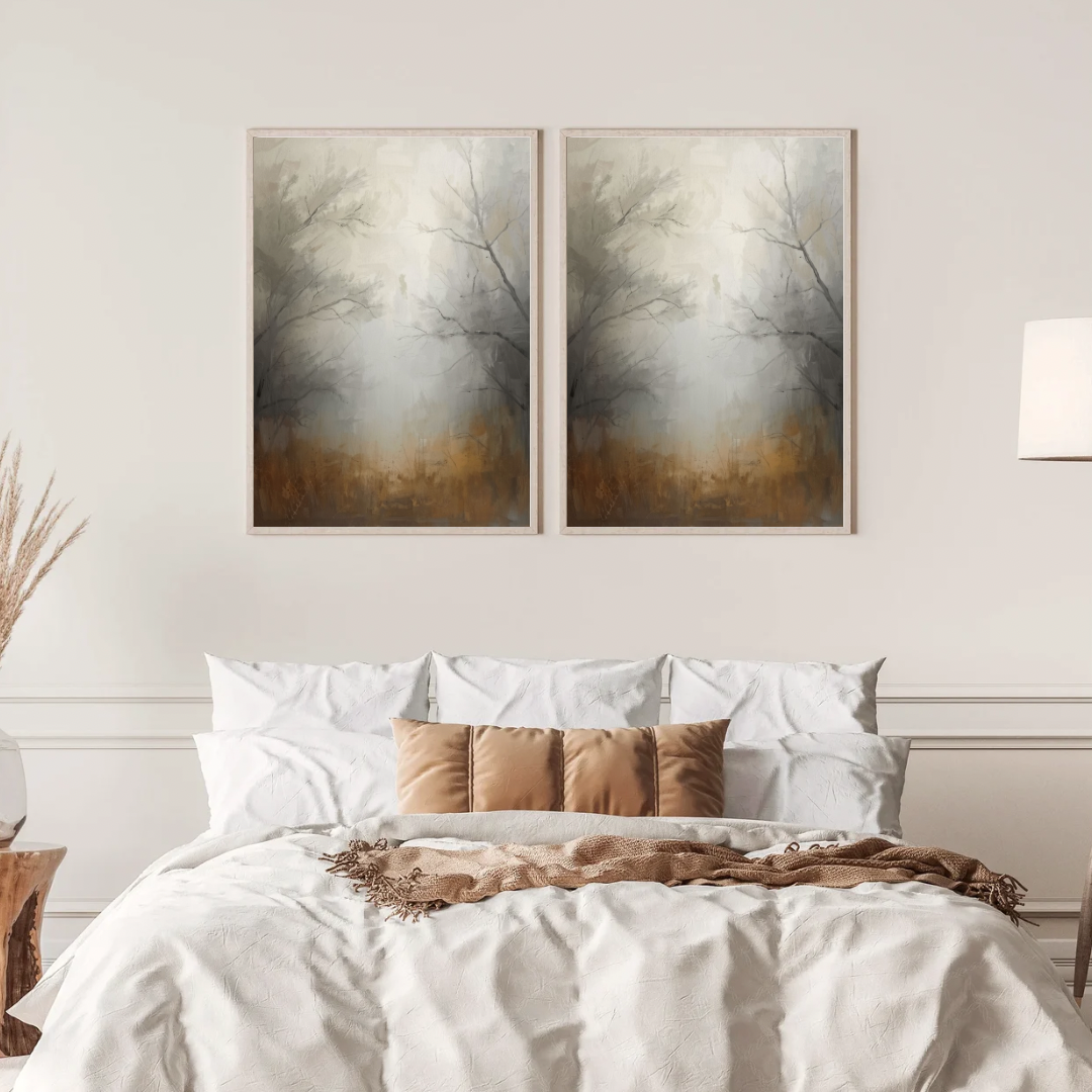 Abstract mistig bos schilderij met kale bomen en warme bruine mistsfeer in twee gouden lijsten naast elkaar aan witte muur boven bed met linnen beddengoed – sereen wall art slaapkamer