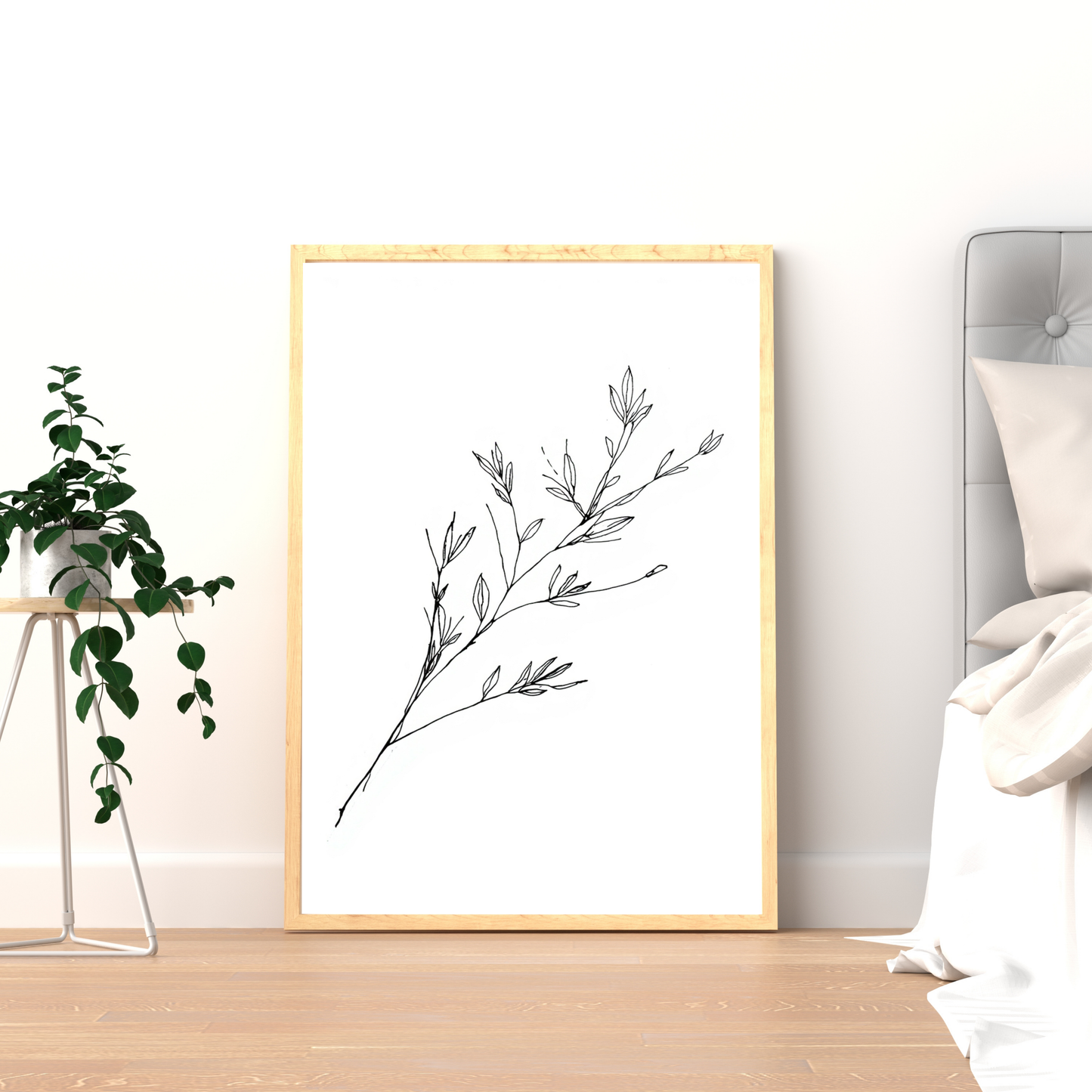 Botanische takjes schilderij met fijne grijze takken en bloesemknoppen in gouden lijst staand op houten nachtkastje naast logeerbed – minimalistisch wall art logeerkamer