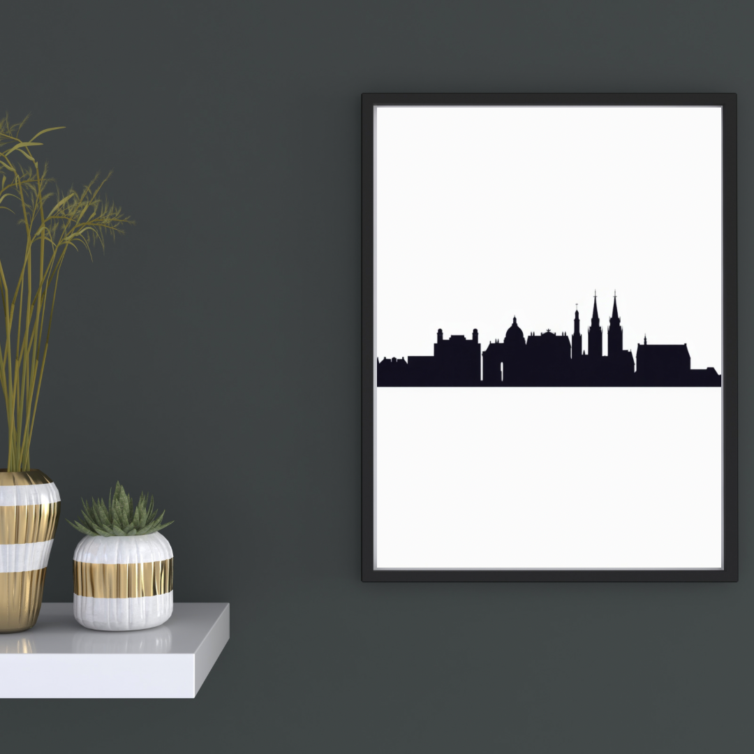 Stadssilhouet skyline canvas schilderij in zwarte lijst aan donkergrijze muur in hal met decoratieve vaas en boeken — minimalistisch wanddecoratie