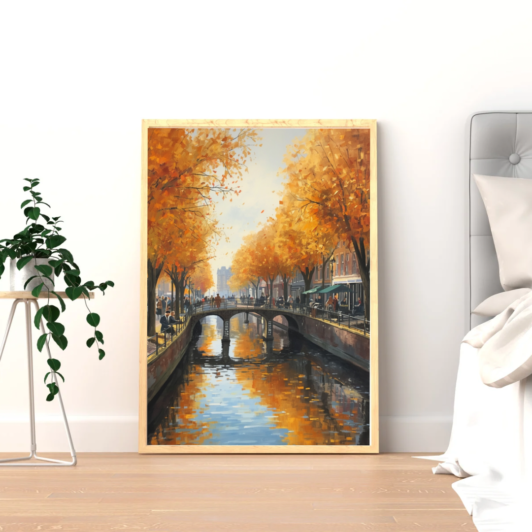 Herfstgracht schilderij in zwarte lijst staand op lichte houten vloer tegen witte muur naast grote groene plant – impressionistisch wall art woonkamer
