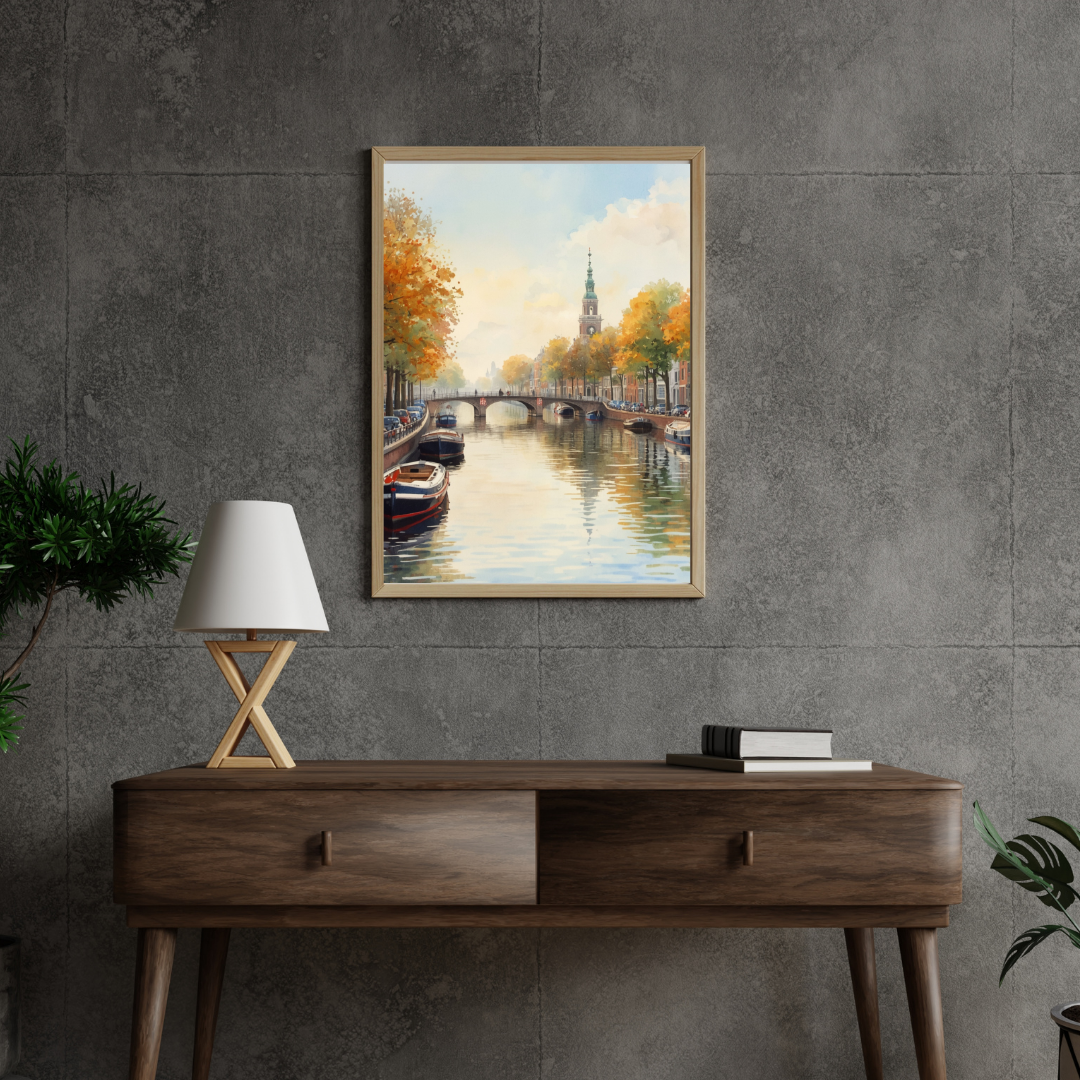 Amsterdam herfst gracht schilderij in zwarte lijst staand op houten bureau met groene plant tegen donkergrijze muur – aquarel wall art thuiskantoor

