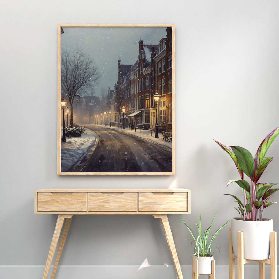 Deventer winterstraat schilderij in zwarte lijst staand op licht houten sidetable met groene plant tegen witte muur – olieverf wall art woonkamer
