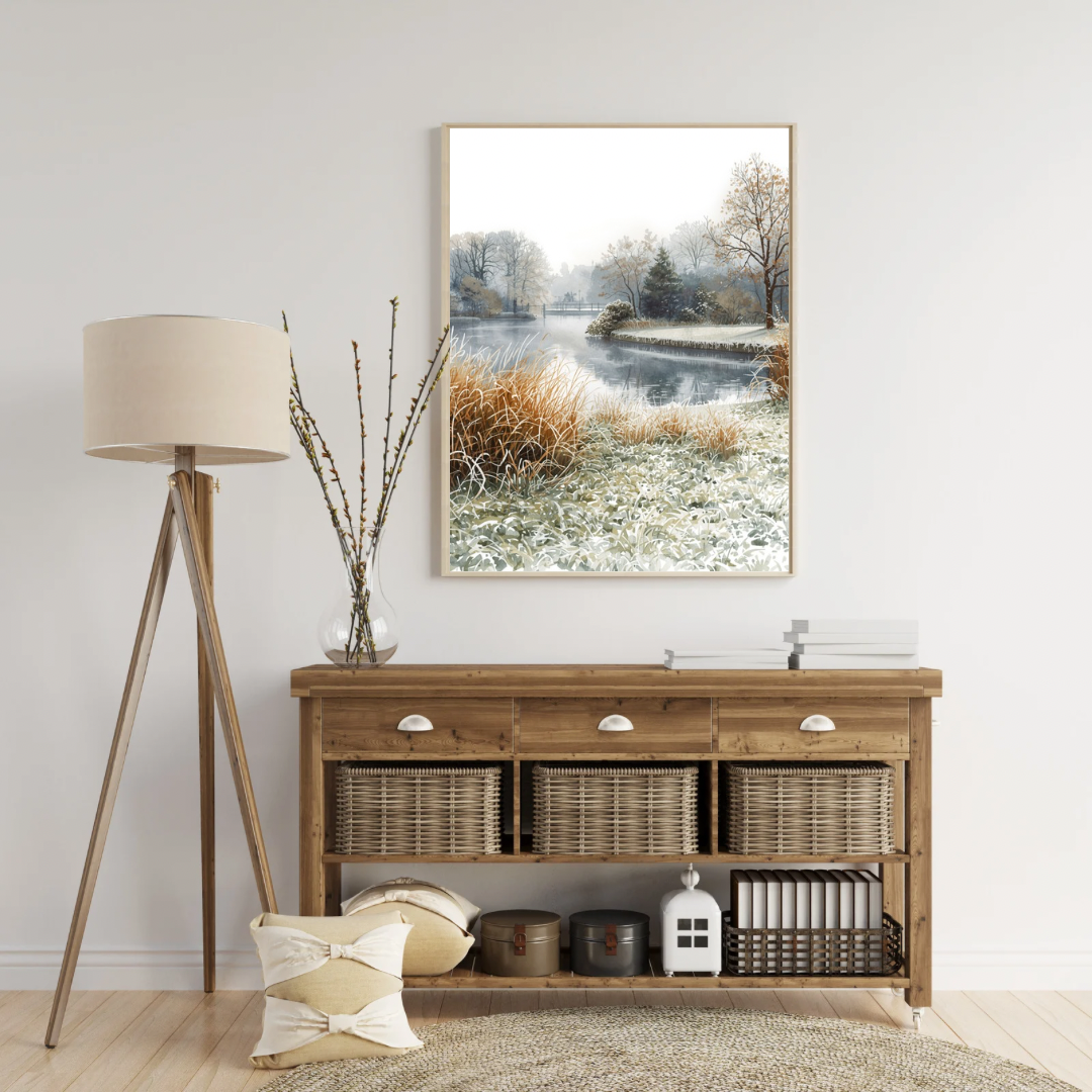 Dordrecht winterlandschap schilderij in witte lijst staand op licht houten sidetable met droogbloemen in vaas tegen witte muur – aquarel wall art woonkamer
