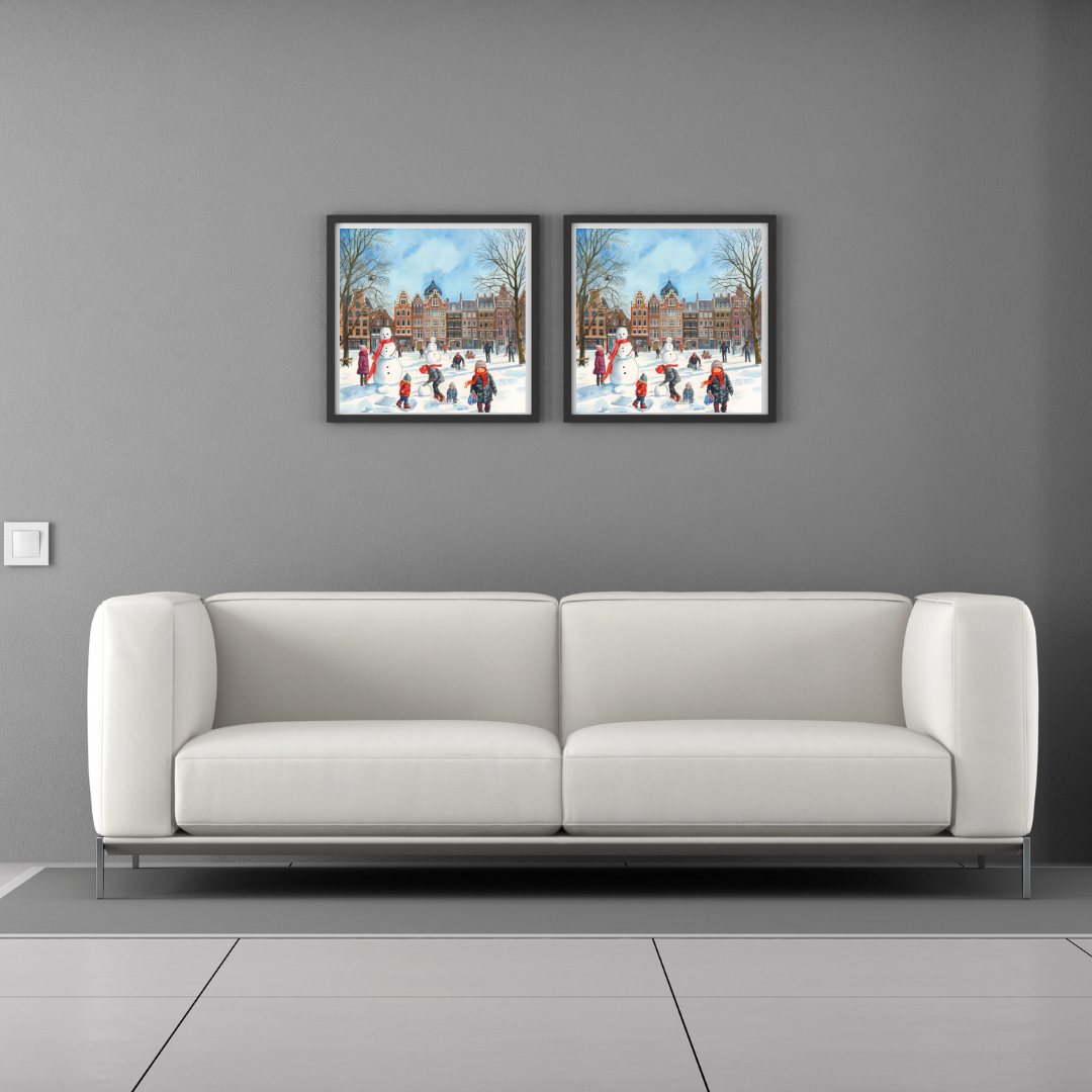 Dordrecht sneeuwpop schilderij als set van twee in grijze lijst aan grijze muur boven witte bank met witte kussens – aquarel wall art woonkamer
