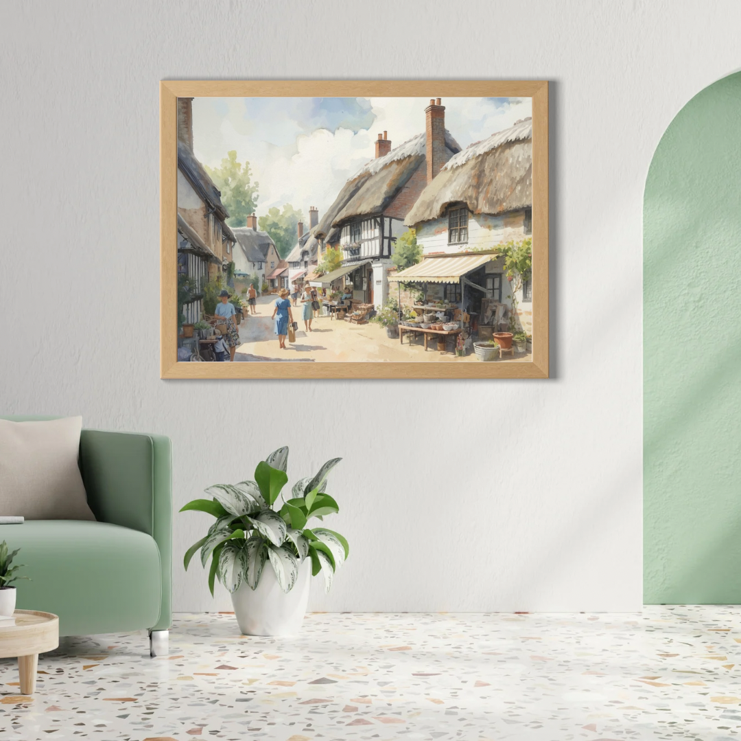 Engels zomers dorpsstraatje schilderij in gouden lijst aan groene muur boven groene bank met grote groene plant en witte hanglamp – aquarel wall art woonkamer
