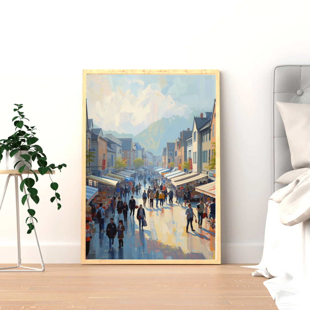Europese marktstraat schilderij in gouden lijst staand op lichte houten vloer naast groene plant tegen witte muur – impressionistisch wall art woonkamer
