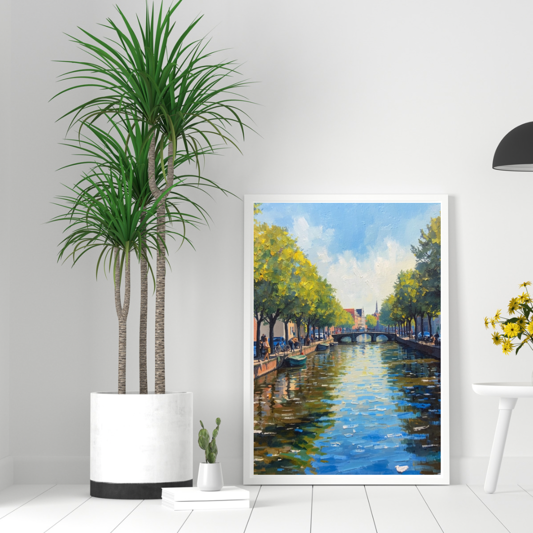Alkmaar zomergracht schilderij in witte lijst staand op witte plank naast grote dracaenapalm en gele bloemen in moderne ruimte – wall art print interieur
