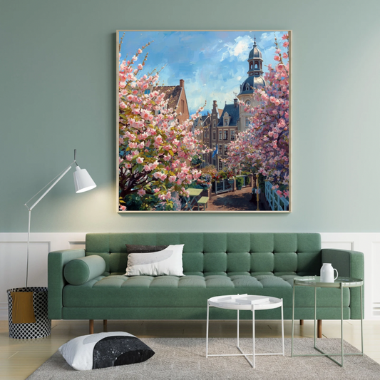 's-Hertogenbosch lentetoren schilderij in zwarte lijst aan saliegroen muur boven groene bank met witte kussens en witte ronde salontafel – wall art print woonkamer
