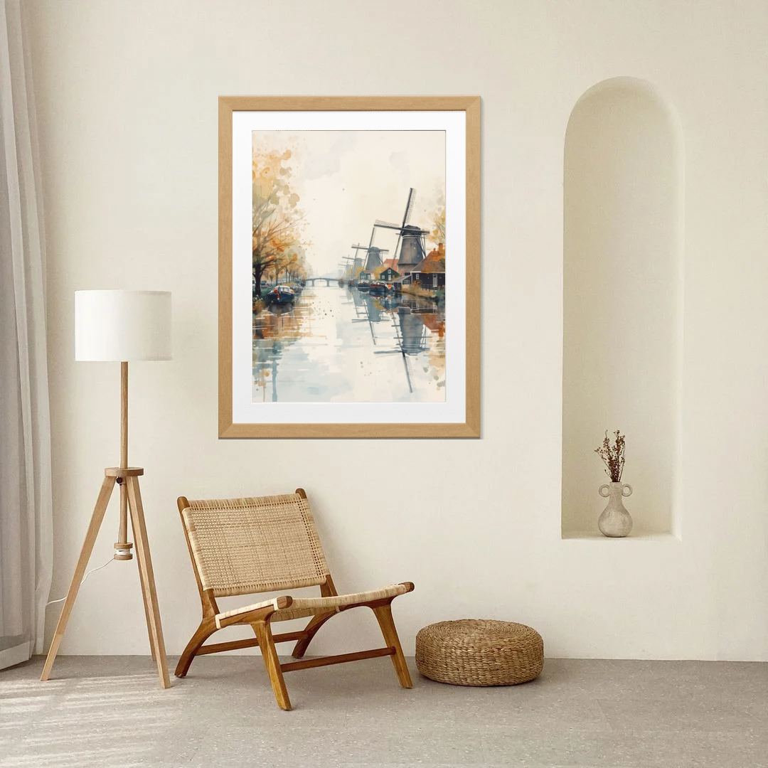 Windmolen aquarel schilderij in houten lijst aan witte boogvormige muur naast houten klapstoelen en witte vloerlamp in lichte neutrale ruimte – wall art print interieur
