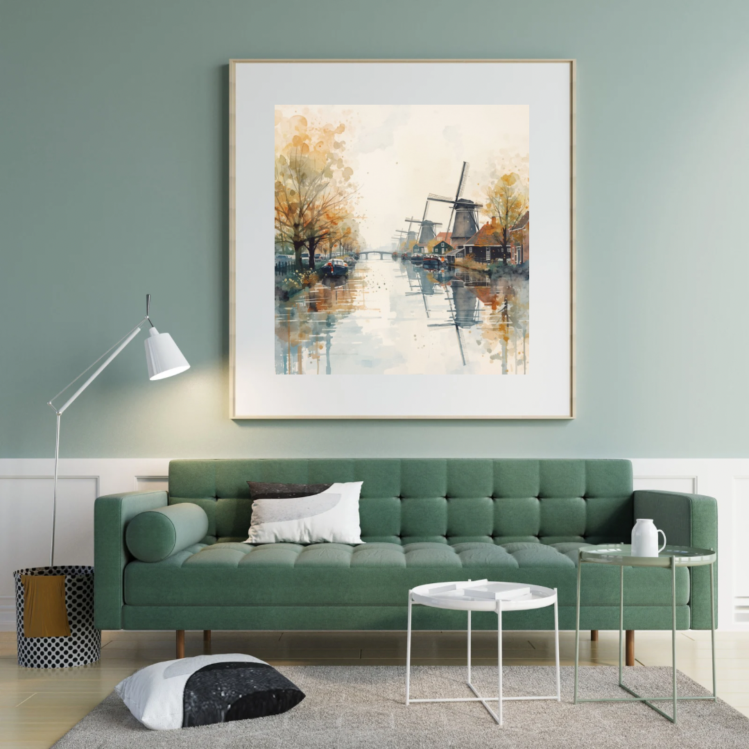 Windmolen aquarel schilderij in witte lijst aan saliegroen muur boven groene bank met witte kussens en witte ronde salontafel in woonkamer – wall art print
