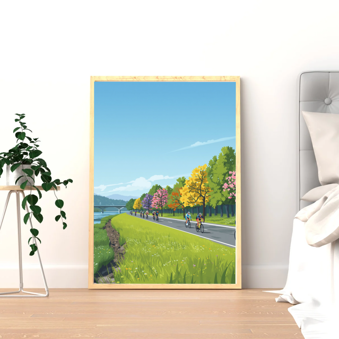 Alphen aan den Rijn herfstweg wielrenners schilderij in gele lijst staand op houten vloer naast grote groene plant en witte muur in slaapkamer – wall art print

