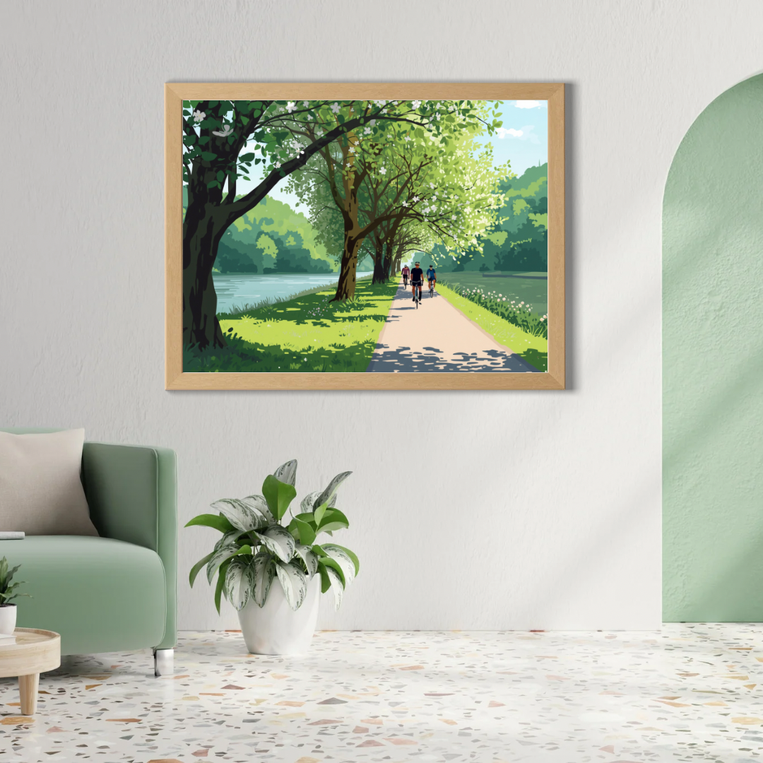 Alphen aan den Rijn lentefietspad schilderij in houten lijst aan witte boogvormige muur boven groene fauteuil met grote tropische plant – wall art print woonkamer
