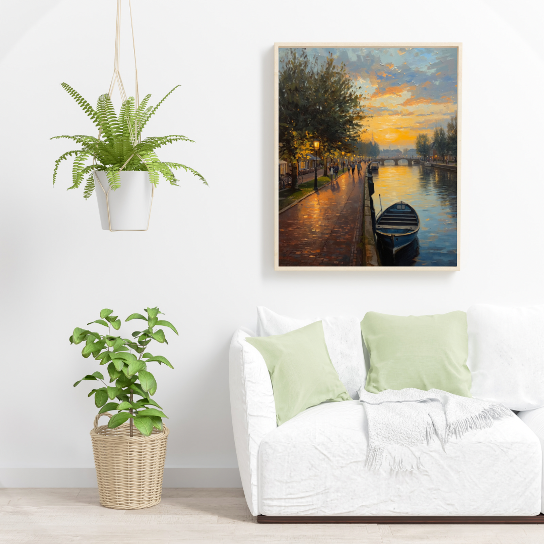 Alphen aan den Rijn Rijnkade zonsondergang schilderij in houten lijst aan witte muur naast grote groene hangplant en witte fauteuil met groene kussens – wall art print woonkamer
