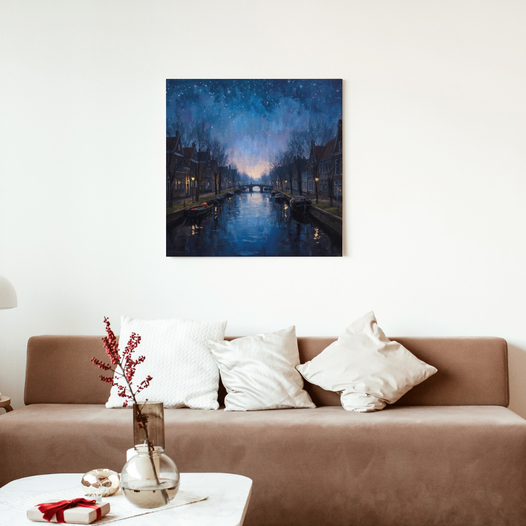 Amsterdam nachtgracht sterrenhemel schilderij als canvas aan witte muur boven bruine bank met witte kussens en witte vaas met rode takken – wall art print woonkamer
