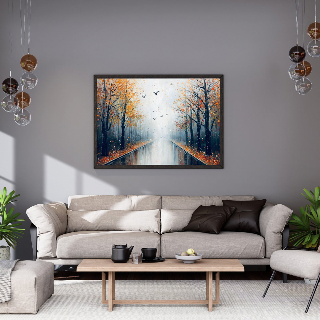 Herfstlaan kale bomen vallende bladeren vliegende vogels schilderij in zwarte lijst aan grijze muur boven lichtgrijze bank met donkere kussens en witte marmeren salontafel – woonkamer schilderij
