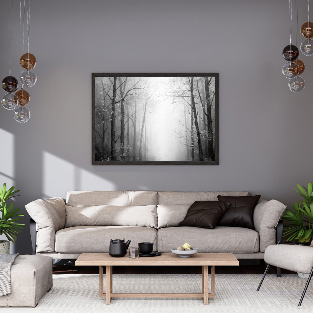 Zwart-wit mistig winterbos kale bomen sneeuwvlokken schilderij in zwarte lijst aan grijze muur boven lichtgrijze bank met donkere kussens en witte marmeren salontafel – woonkamer schilderij
