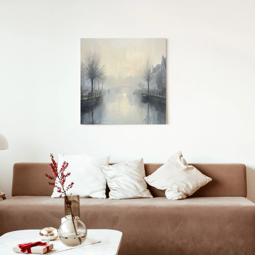 Mistige gracht winterbomen schilderij in zwarte lijst aan witte muur boven bruine bank met witte kussens en takken in vaas op houten salontafel – wall art print woonkamer
