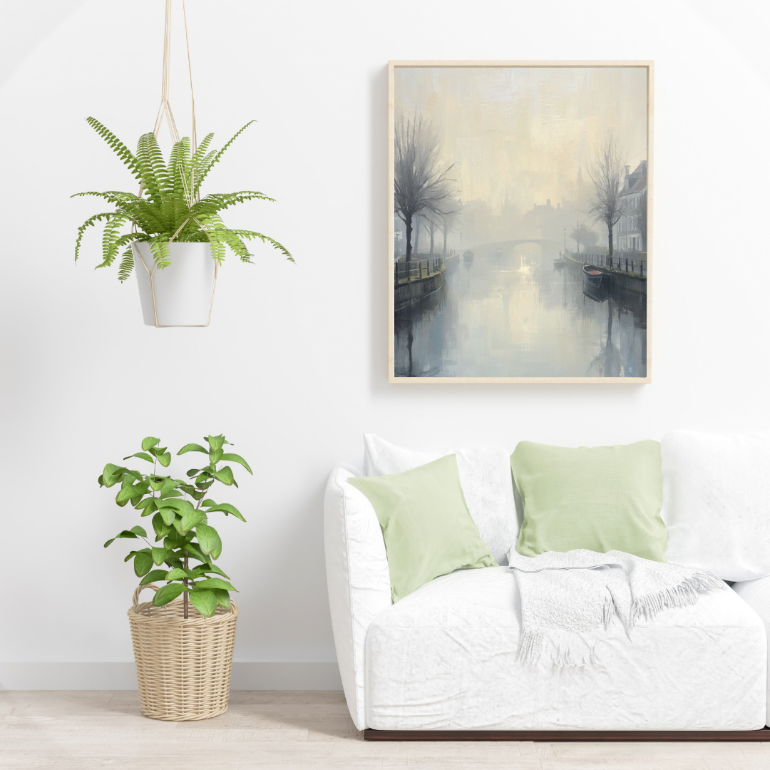 Mistige gracht winterbomen schilderij in zwarte lijst aan witte muur boven witte bank met lichtgroene kussens en witte plant – wall art print woonkamer

