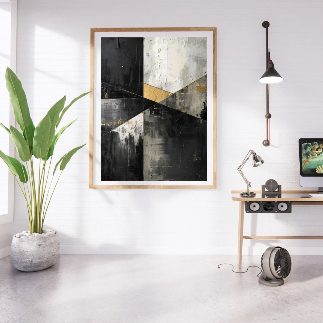 Abstract geometrisch zwart grijs goud schilderij in naturel houten lijst aan witte muur naast grote groene plant en houten bureau met lamp – abstract olieverf wall art studeerkamer
