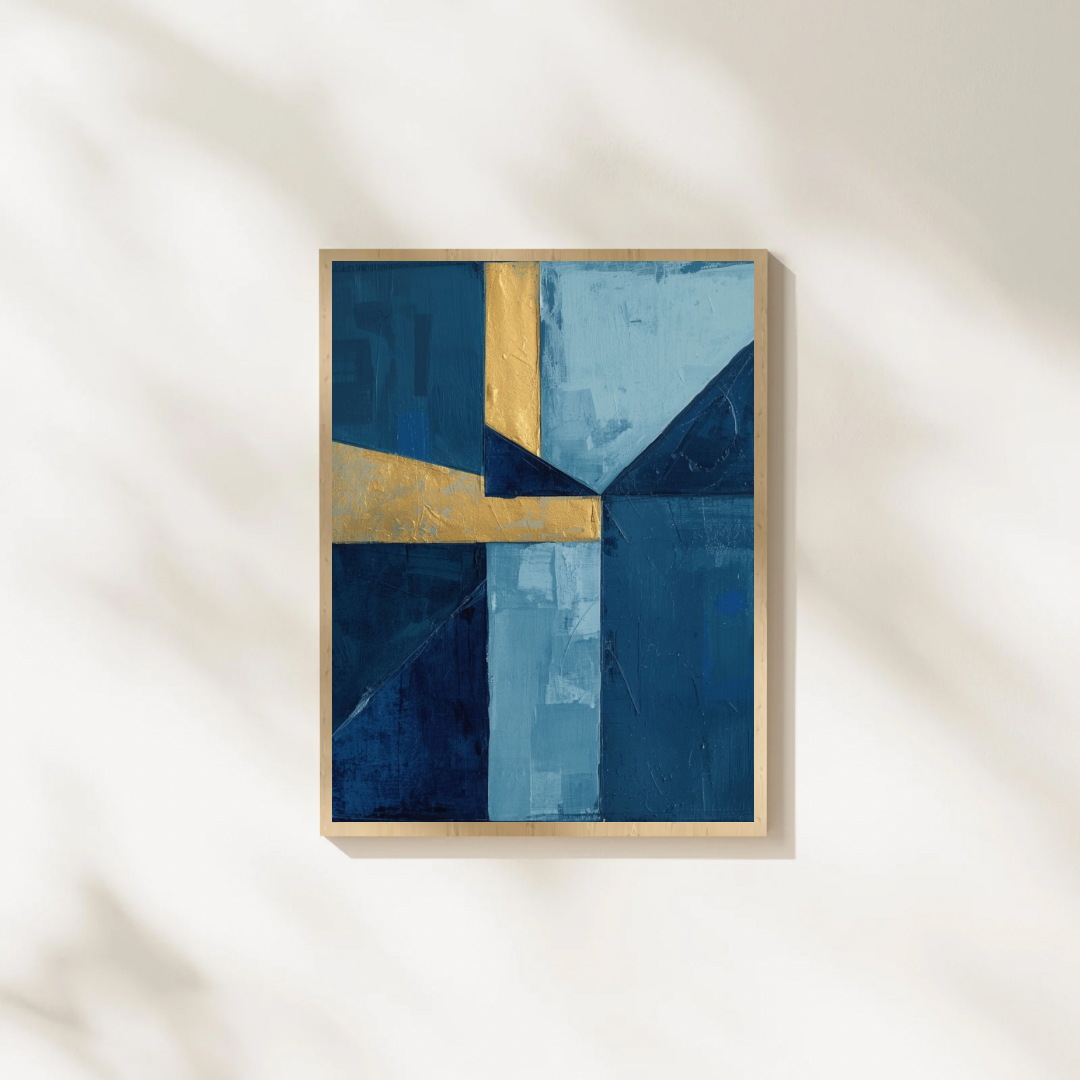 Abstract geometrisch blauw goud schilderij in gouden lijst staand op witte ondergrond tegen witte muur – modern wall art studeerkamer
