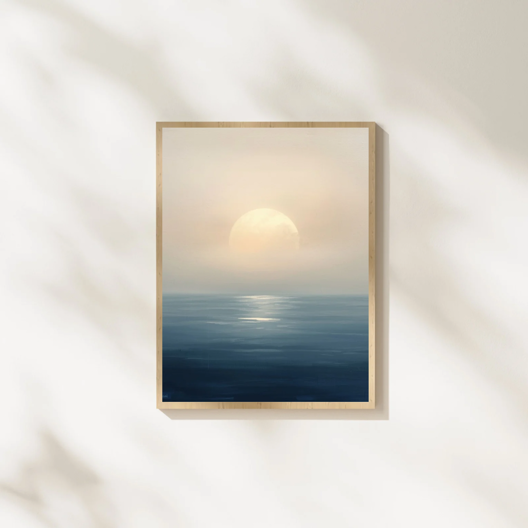 Abstract zonsondergang zee schilderij met gouden zon en mistige horizon in gouden lijst staand op witte ondergrond tegen witte muur – dromerig wall art slaapkamer
