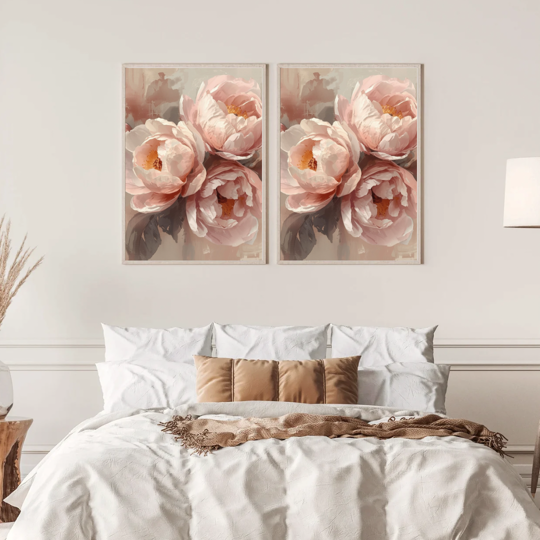 Pioenrozen schilderij met zachte roze pioenen in volle bloei in twee gouden lijsten naast elkaar aan witte muur boven bed met linnen beddengoed – botanisch wall art slaapkamer
