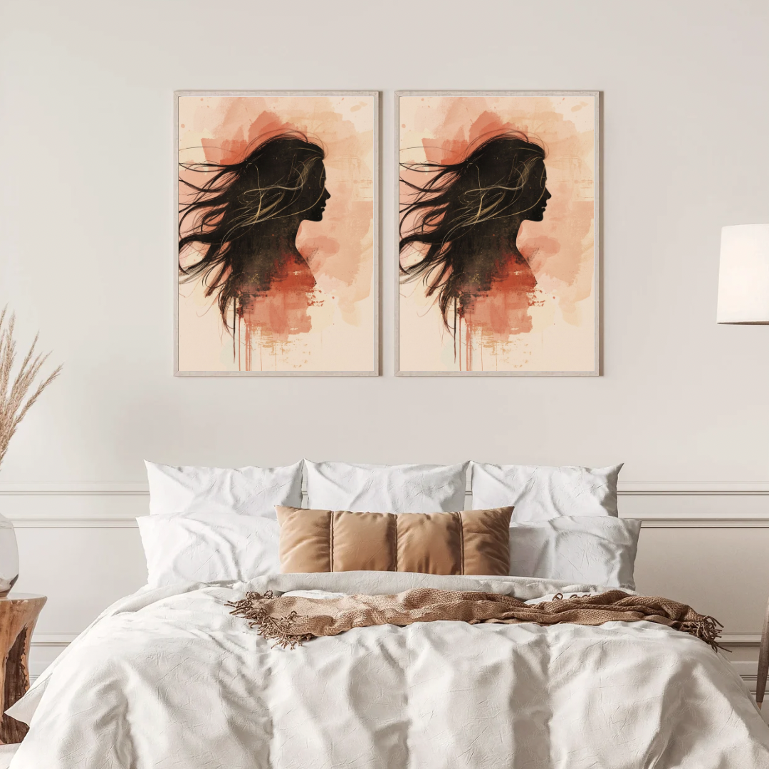 Vrouw silhouet schilderij met zwart profiel en roze aquarel verfwolk in twee gouden lijsten naast elkaar aan witte muur boven bed met linnen beddengoed – vrouwelijk wall art slaapkamer
