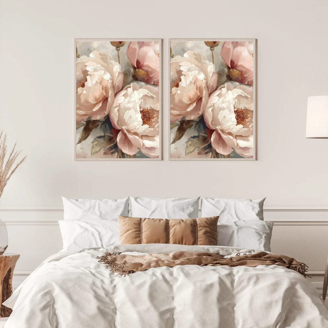 Pioenrozen close-up schilderij met poederroze pioenen in volle bloei in twee gouden lijsten naast elkaar aan witte muur boven bed met linnen beddengoed – botanisch wall art slaapkamer
