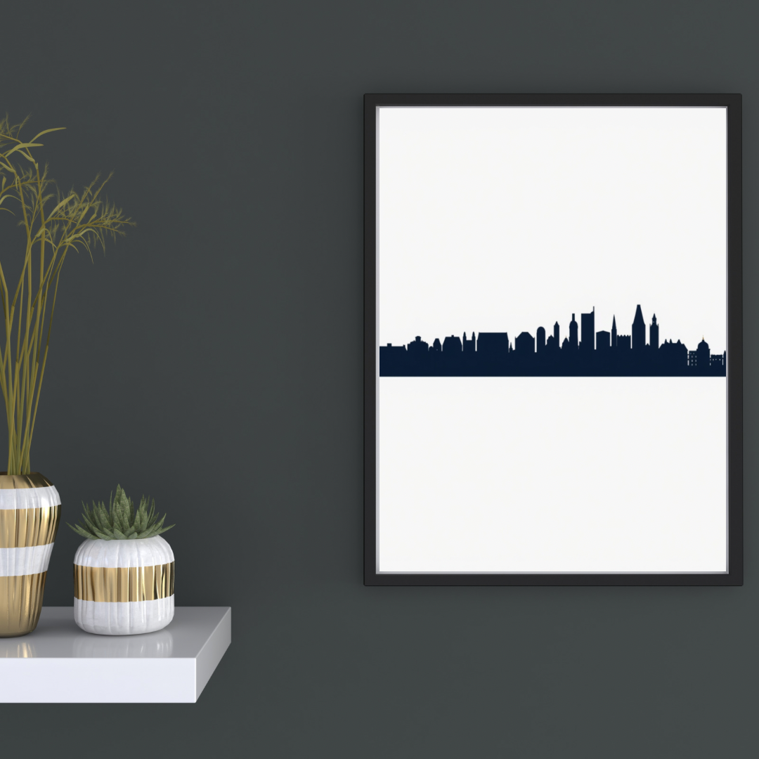 Stadssilhouet skyline canvas schilderij in zwarte lijst aan donkergrijze muur in hal met decoratieve vaas en boeken — minimalistisch wanddecoratie
