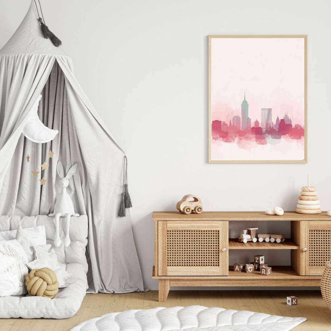 Zachte roze aquarel stadsskyline canvas schilderij in lichte lijst aan witte muur boven houten commode met hemelbed in lichte babykamer — elegante wanddecoratie
