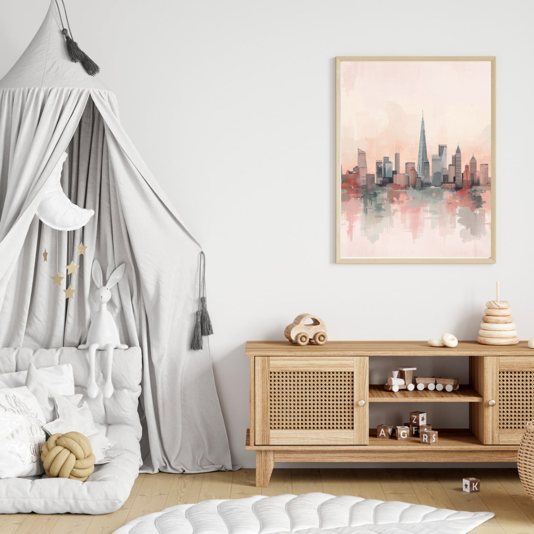 Roze aquarel stadsskyline canvas schilderij in lichte lijst aan witte muur boven houten commode met hemelbed in moderne babykamer — dromerige wanddecoratie
