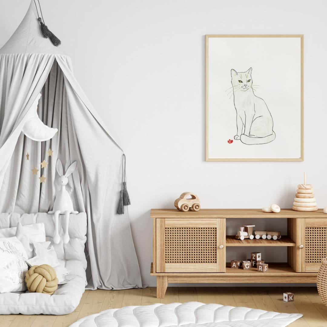 Sierlijk katje canvas schilderij in naturel houten lijst aan witte muur boven houten commode met hemelbed in lichte babykamer — minimalistische wanddecoratie

