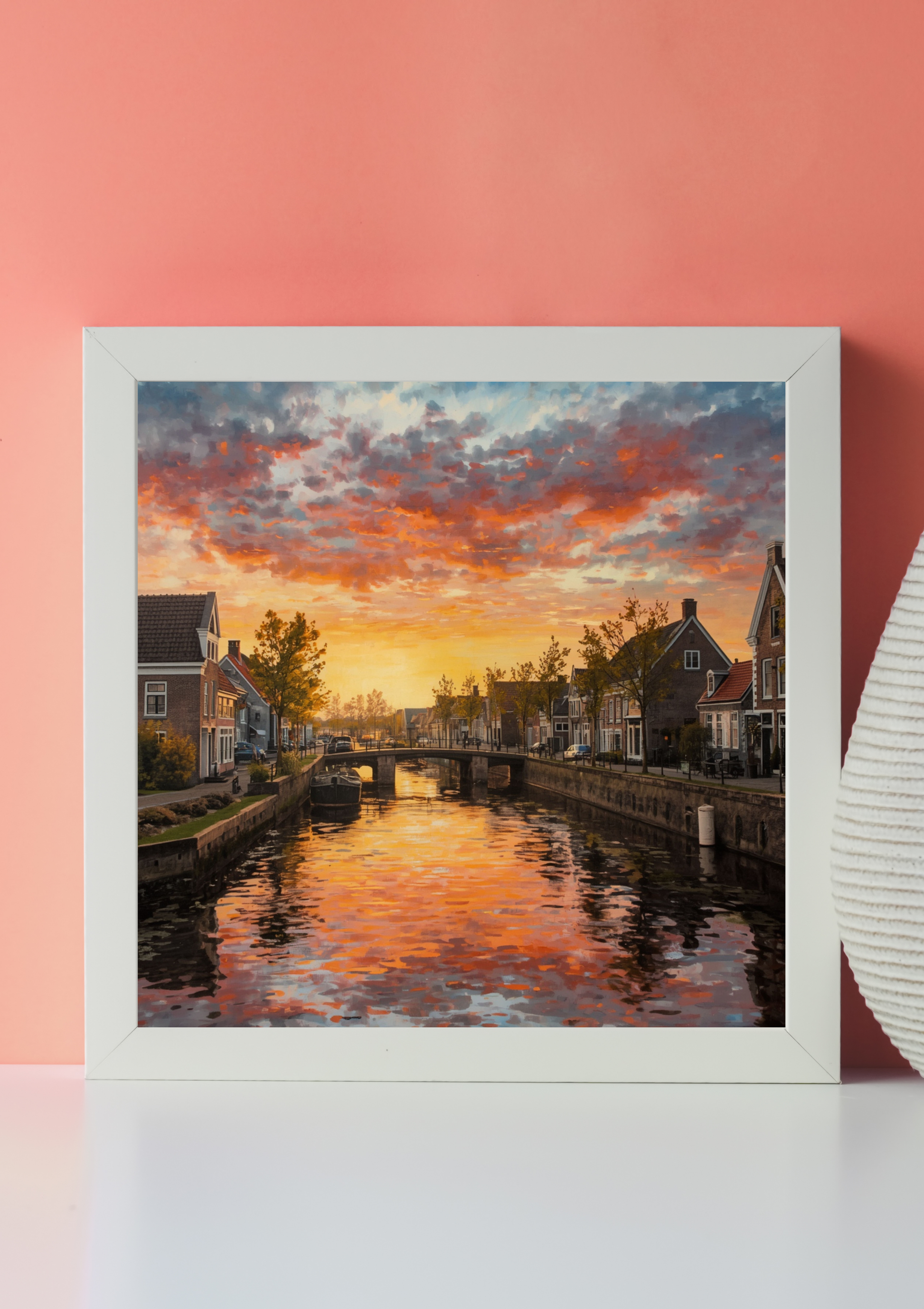 Groningen zonsondergang kanaal canvas schilderij met gouden reflecties en traditionele huizen in wit frame op roze muur in moderne woonruimte — premium wanddecoratie
