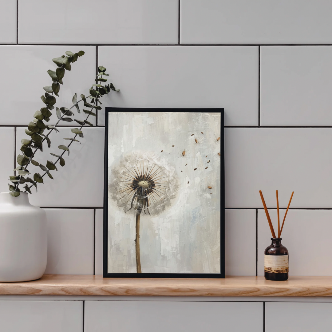 Paardenbloem schilderij in zwarte lijst staand op houten plank aan grijze tegelmuur naast witte vaas met eucalyptus en bruine diffuser – olieverf wall art toilet
